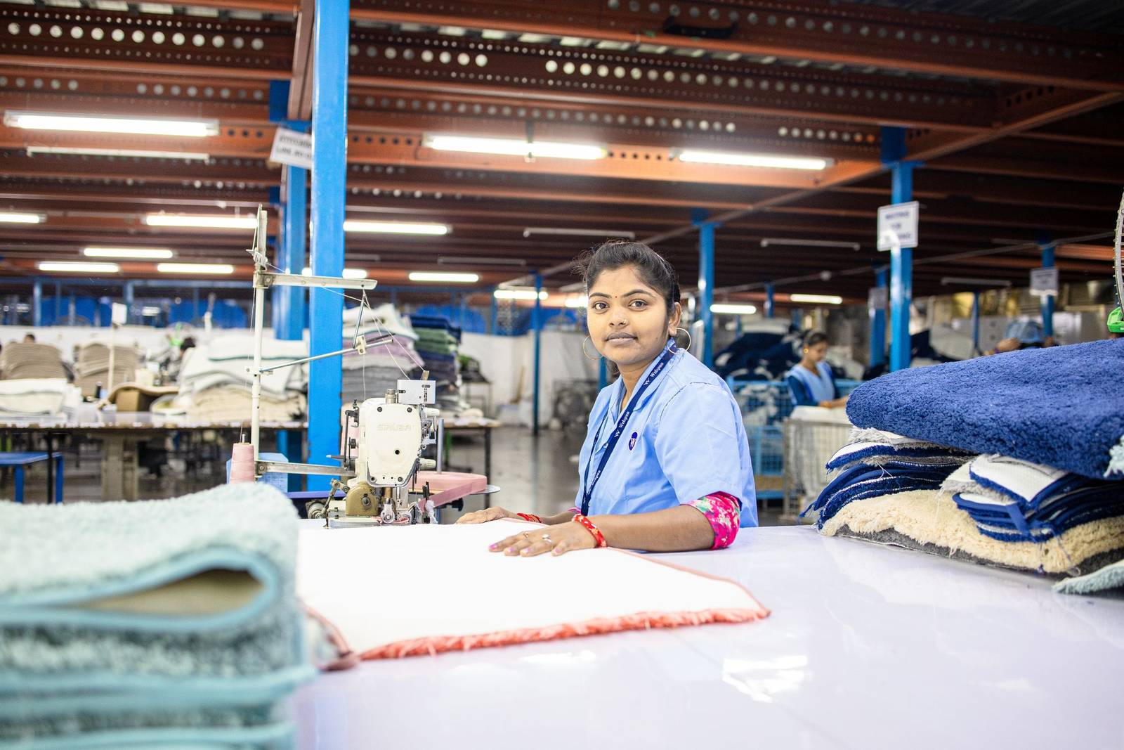Garment worker reviewing fabric beside a sewing station