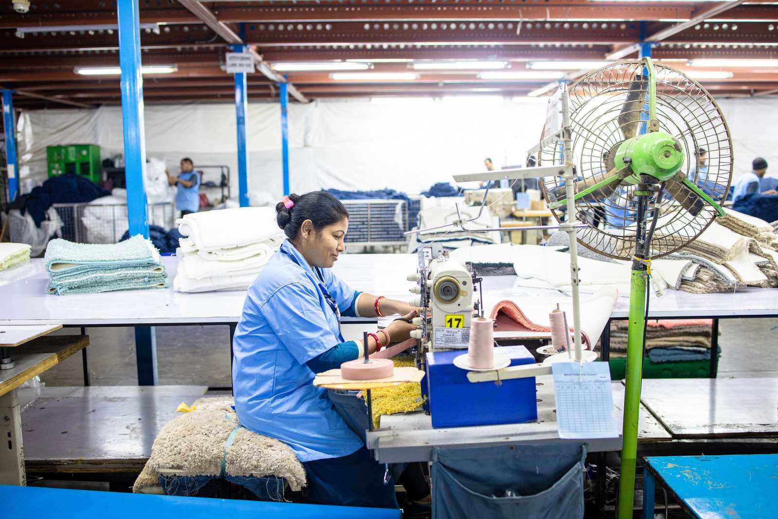 Sportswear production team working with fabric at sewing stations