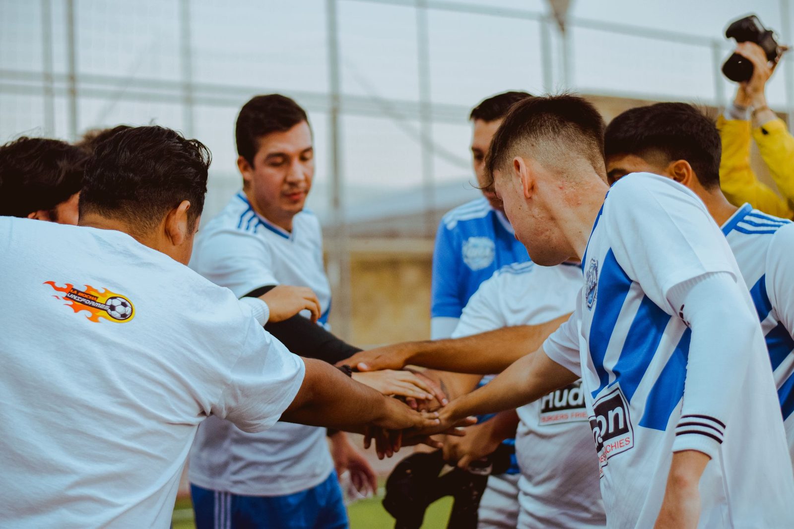 Football team members joining hands before a match