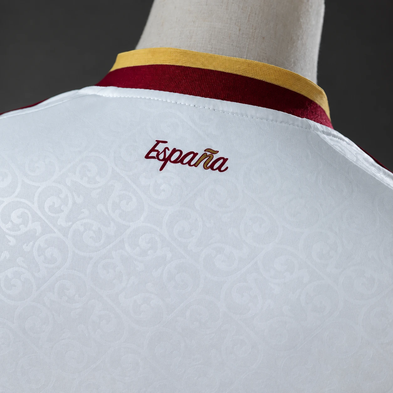 Close-up of a football jersey back neck with burgundy España detail and collar trim